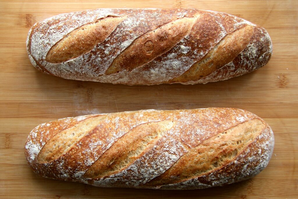 Home Two crusty artisan loaves of bread on a wooden table