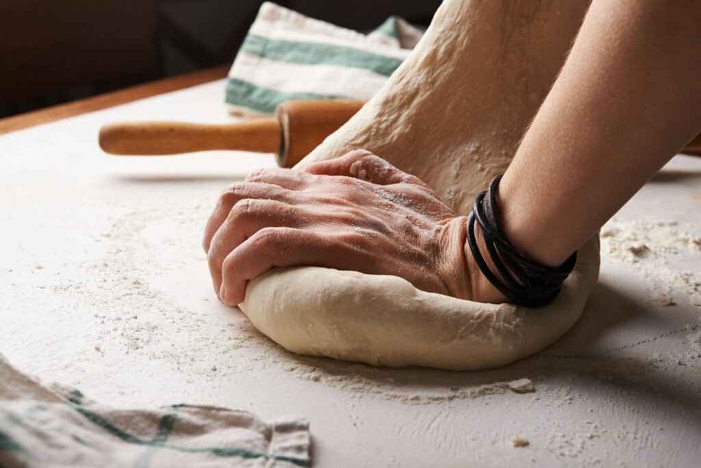 Home Baker kneading dough by hand on a floured surface