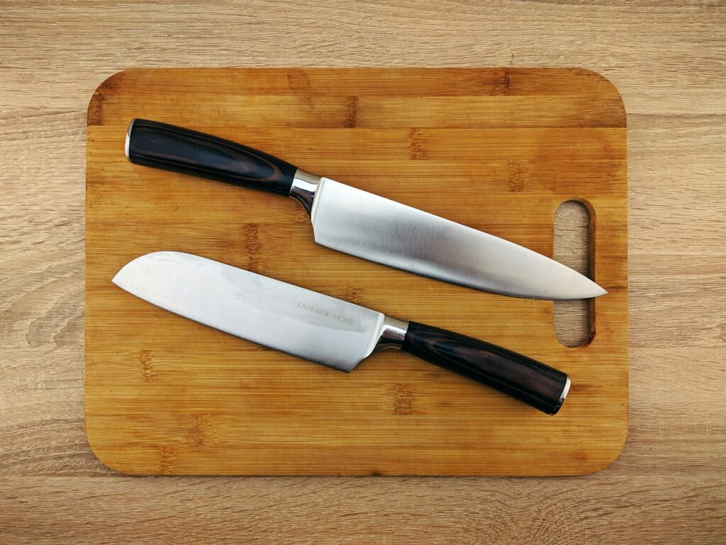 Home Two chef knives resting on a wooden cutting board